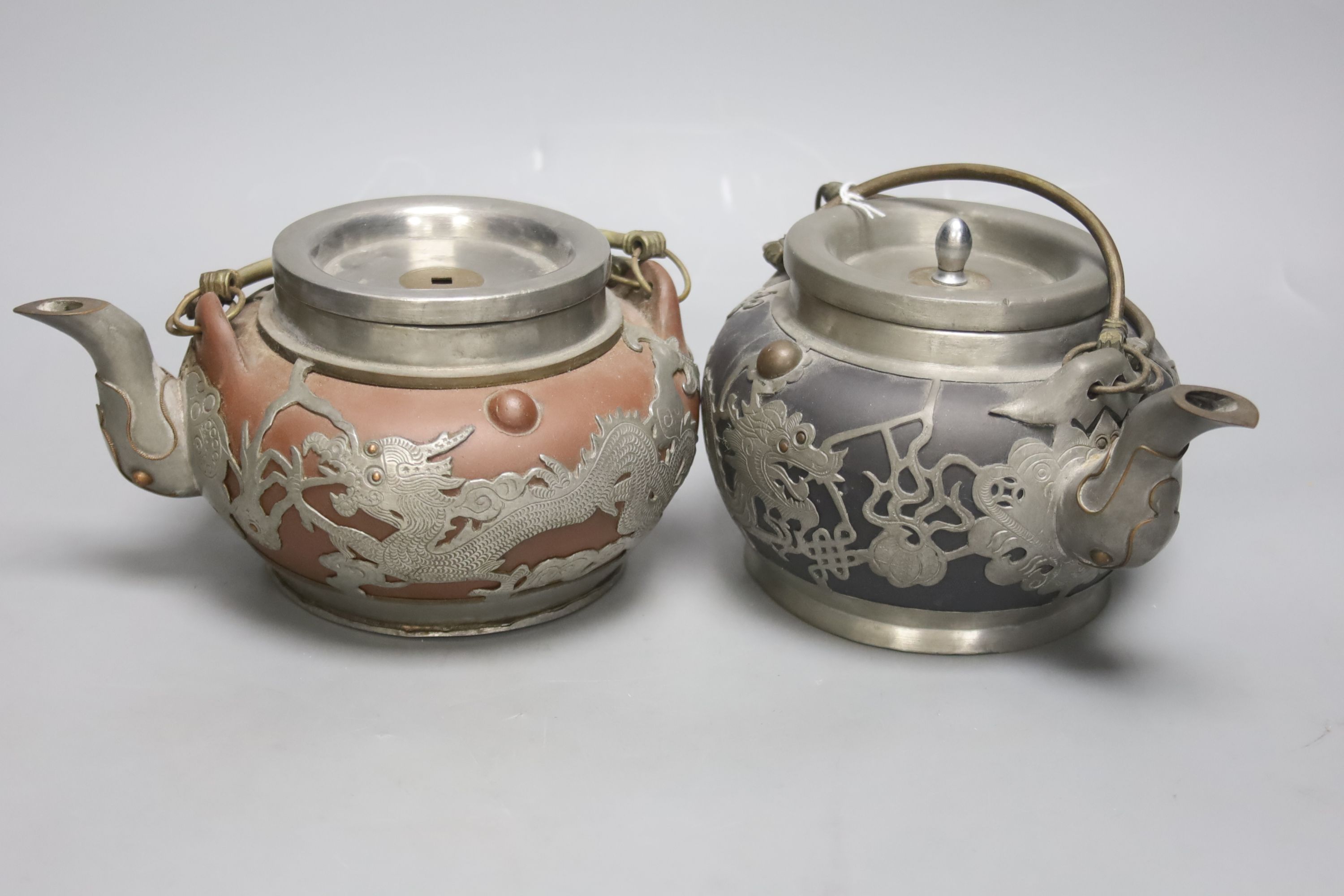 A trio of Chinese pewter mounted Yixing teapots